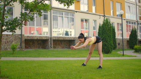 Warm-up-of-female-athlete-performing-slopes-in-the-park-on-the-grass